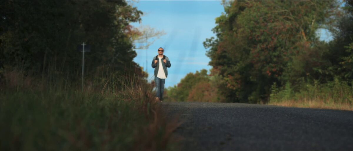 Un homme sur une route de campagne, dans Go West, court métrage.